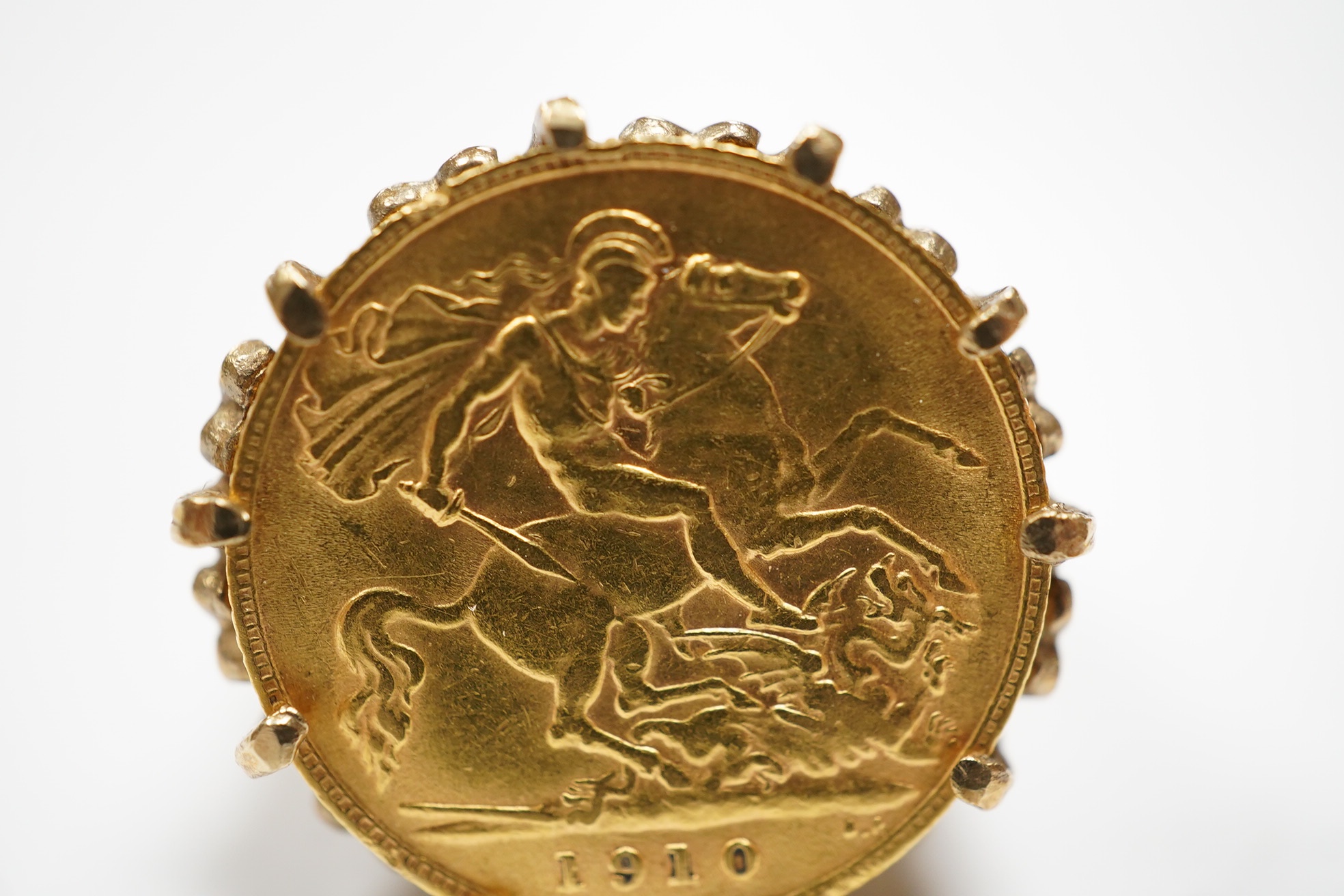 A George V gold half sovereign, in a later pierced and carved 9ct god ring mount, size P, gross weight 10 grams. Condition - fair.